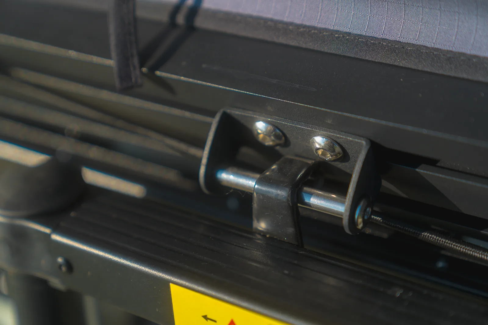 Gros plan sur un support de fixation et les boulons d'une tente de toit sur une galerie